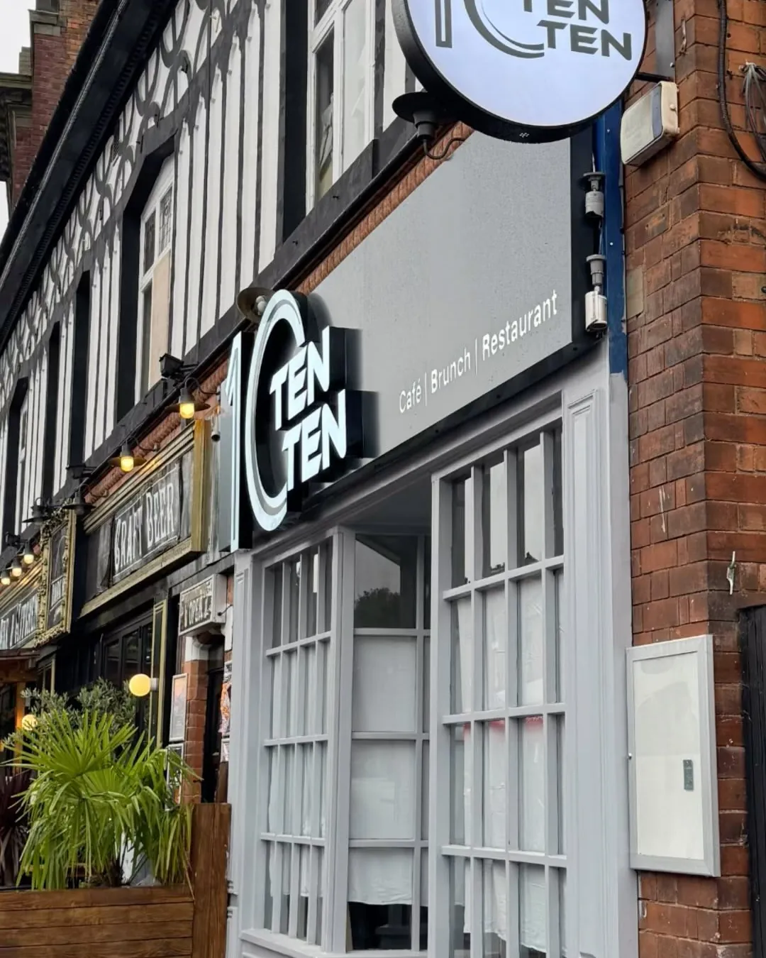 TenTen’s shopfront on Alcester Road — the round TenTen sign above grey-framed windows in a red-brick Moseley terrace.