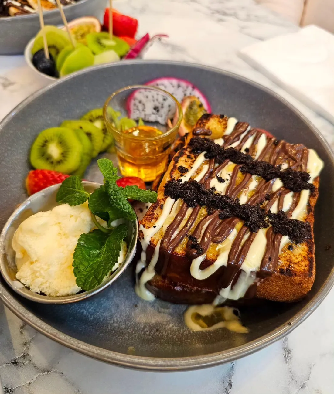 Baked brioche French toast at TenTen — a charred slab under milk and white chocolate and Oreo crumb, with vanilla ice cream, kiwi, strawberry and dragon fruit alongside.